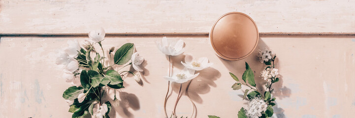 Obraz na płótnie Canvas Natural organic cosmetics: serum, cream, mask on wooden background with flowers. Skincare concept