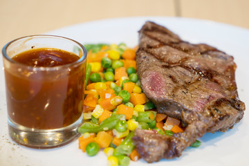Tasty grilled steak with sauce on a plate