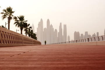Morning walk, a man riding a bicycle on the road with a beautiful view of Dubai. UAE