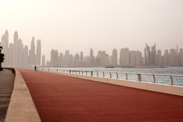 Morning run, a man runs along the road with a beautiful view of Dubai. UAE