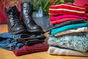pile of second hand clothing and shoes with computer on floor