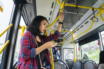 Young woman with phone inside the bus