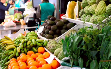 Side view of a counter with different fruits on the Funchal market. Cropped shot, horizontal, close-up, place for text. Concept of tradition and healthy eating.