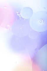 Blurred abstract background. Image of pink, blue, gray and yellow circles of different sizes. Cropped shot, vertical, abstract, blurred, free space, nobody.