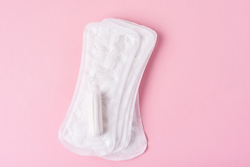 Sanitary pad and menstrual tampon on a pink background