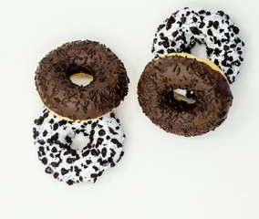 Donuts  with chocolate glazed with sprinkles donuts isolated on white black abstract background