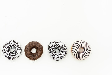 Donuts  with chocolate glazed with sprinkles donuts isolated on white black abstract background