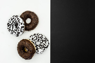 Donuts  with chocolate glazed with sprinkles donuts isolated on white black abstract background