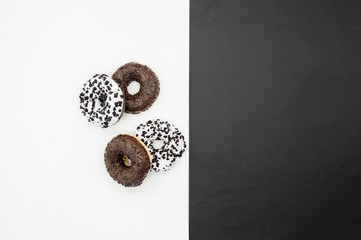 Donuts  with chocolate glazed with sprinkles donuts isolated on white black abstract background