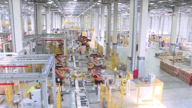 Technological production line at the plant. Scene. Team welding robots represent the movement. In the automotive parts industry