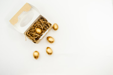 Golden Easter Eggs in a box with golden stars on white background . Easter Holiday concept abstract background copyspace top view