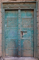 Ancient door carved with engravings of an ancient mud house in Oman