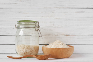 Rice grains in wooden bowl and glass jar