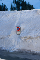 Straßenschild umgeben von Schneemassen