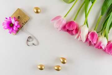 Pink and white tulips and audio cassette on white background.