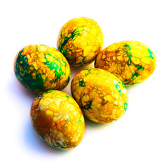 handmade yellow green easter eggs painted marbled over white background