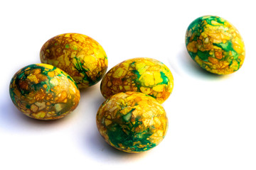 handmade yellow green easter eggs painted marbled over white background