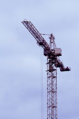 High-Altitude Tower Crane Isolated Over Blue Sky Background 