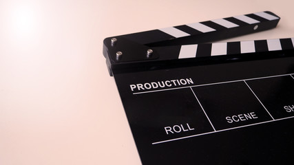 Fototapeta na wymiar Clapper board or movie slate use in video production and cinema industry. It's black color on white background with flare light.