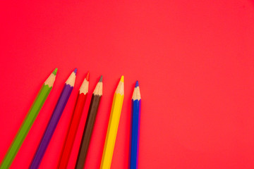 Coloring pencils on colorful background. School stationery and office supplies. Colored pencils abstract background. Lots of pencils of different colors. Creative flat lay.