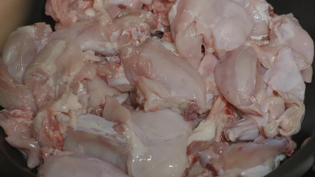 Rabbit meat spread on a frying pan for frying.