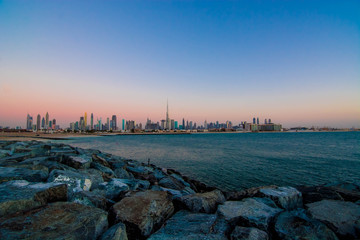 Futuristic Skyscraper buildings view from beach island with blue waterfront and  twilight sky background
