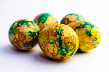 handmade yellow green easter eggs painted marbled over white background