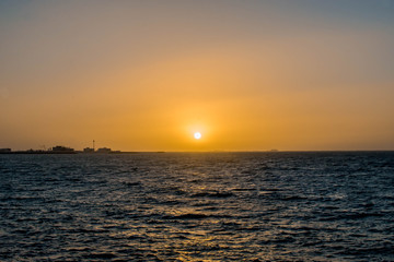 Beautiful Sun View at Beach with orange sky and yellow light reflection on sea water waves