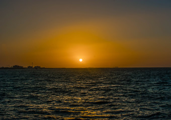 Beautiful Sun View at Beach with orange sky and yellow light reflection on sea water waves