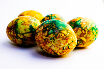 handmade yellow green easter eggs painted marbled over white background