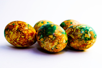 handmade yellow green easter eggs painted marbled over white background