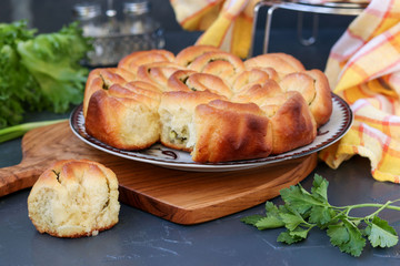Yeast pie with herbs and garlic located on a dark background
