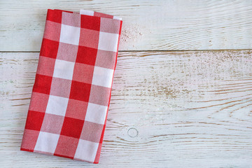 Fototapeta na wymiar Red and white checkered napkin on the rustic white paint wooden background top view with copy space