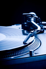 Record player playing LP in dark room, macro picture