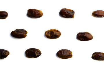 sweet dried dates laid out in several rows on a white background