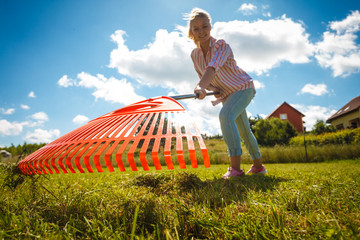 Unusual angle of woman raking leaves