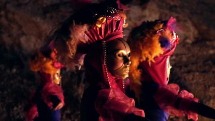 portrait of girls dancers in bright dresses and gold masks take a step back and turn in profile.