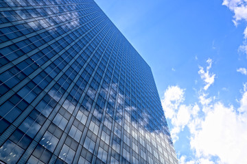 ガラス張りのオフィスビルと青空