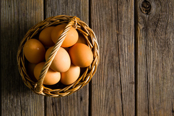 basket of eggs on old wooden background