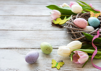 Nest with  Easter eggs and tulips bouquet