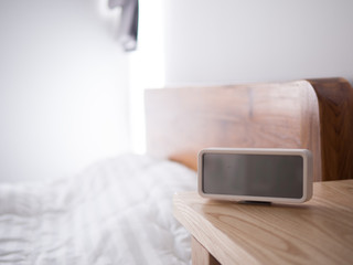 blank displays on digital alarm clock's screen on wood table.