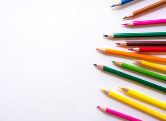 shaved colour pencils on white background, space for text.