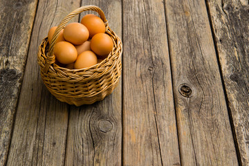 basket of eggs on old wooden background
