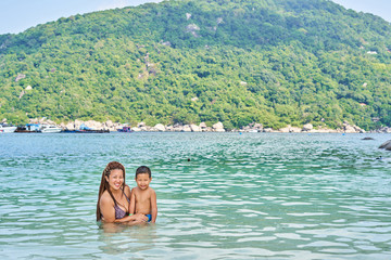 Mom and son Asians bathe in the sea