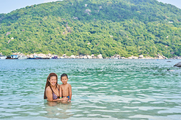 Mom and son Asians bathe in the sea