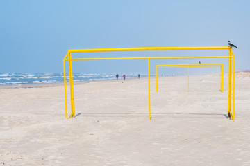 Yellow football goal on the beach.