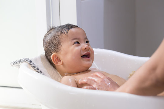 Asian Baby Boy Taking A Bath By Mom. Hygiene And Care For Young Children Concept