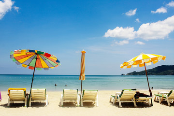 Sea landscape with colorful beach umbrellas and  chairs on tropical beach (boost up color process)