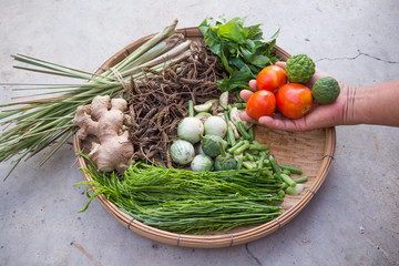 Close up of Thai herb's basket,on the right side show some tomatoes and bergamots in the hand