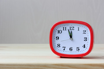 red rectangular plastic alarm clock on the table.
